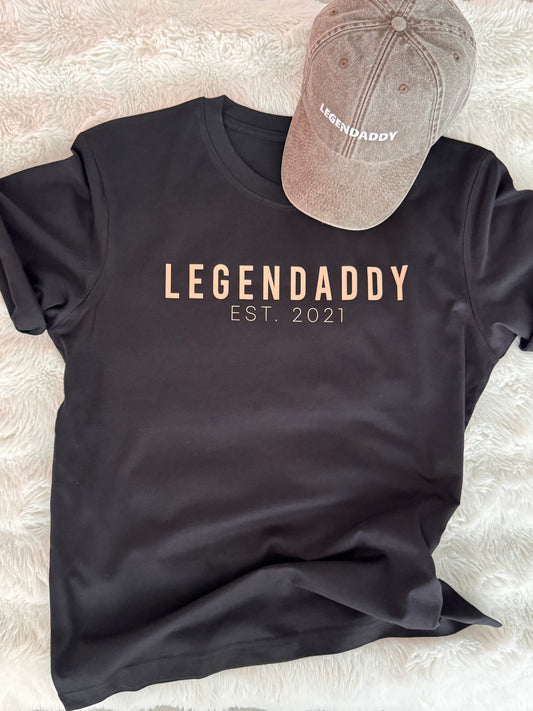 Musta legendaddy-t-paita ja ruskea brodeerattu lippalakki.