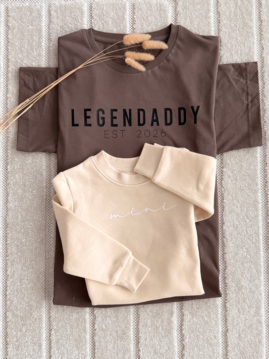 A styled flat-lay of two sweatshirts on a textured gray knit blanket.