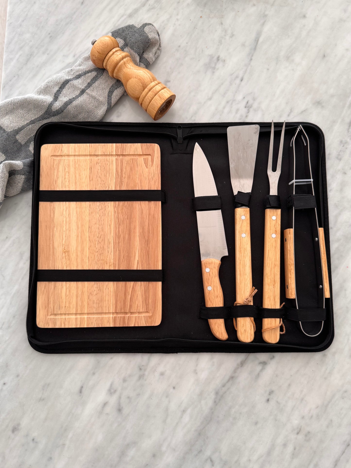 Set of wooden knives and tools in a black case on a marble surface