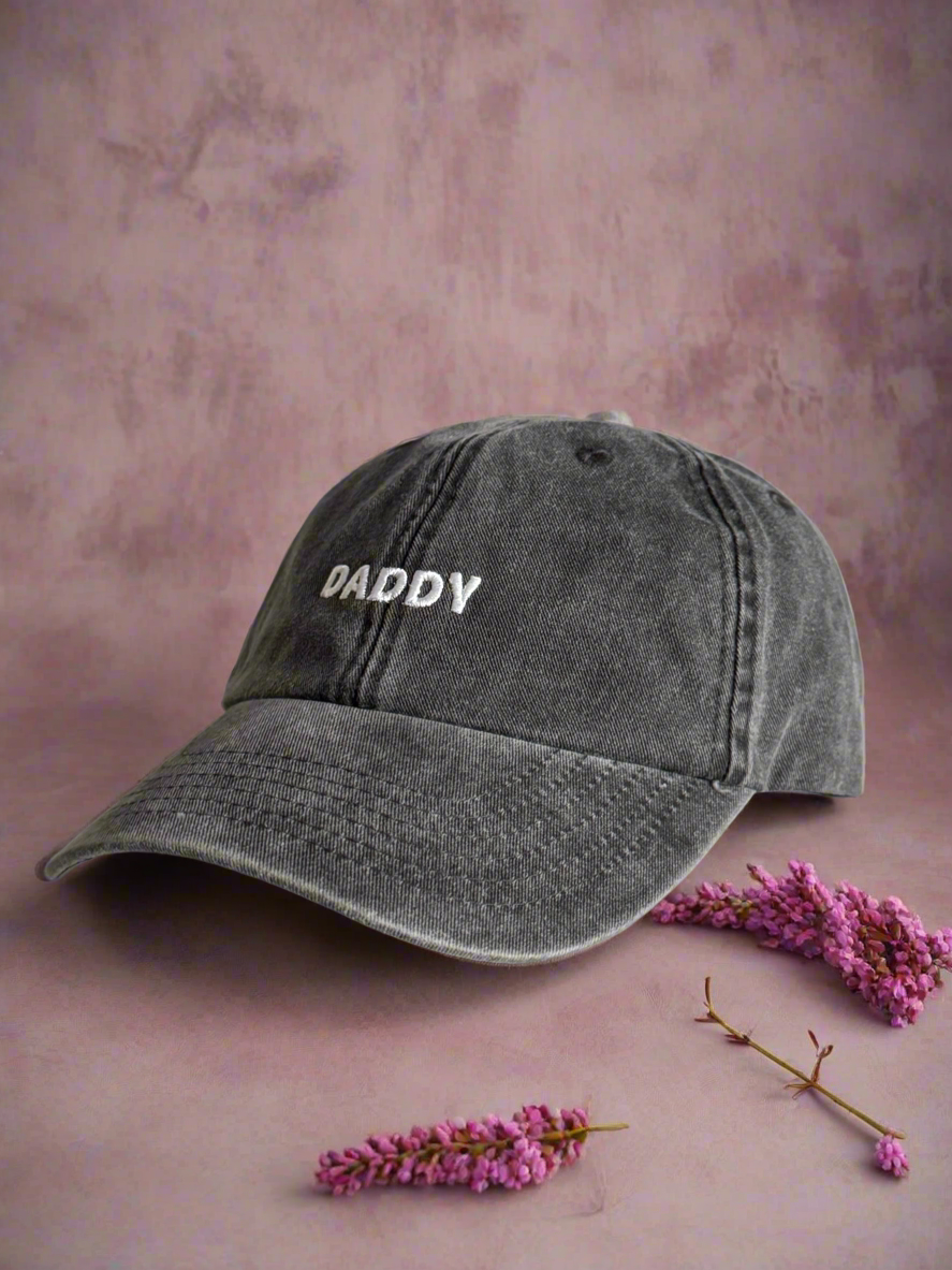 light black cap with 'DADDY' text on a pink background with flowers