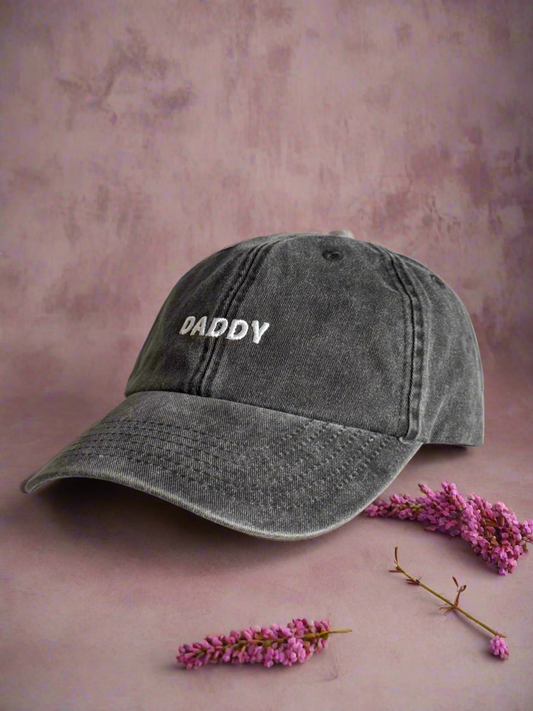 light black cap with 'DADDY' text on a pink background with flowers